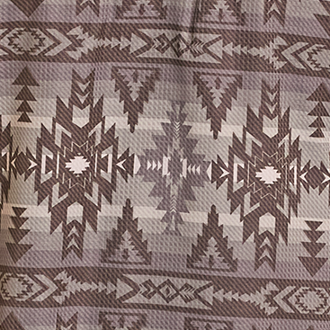 Man wearing a patterned long-sleeve shirt and cowboy hat on a white background