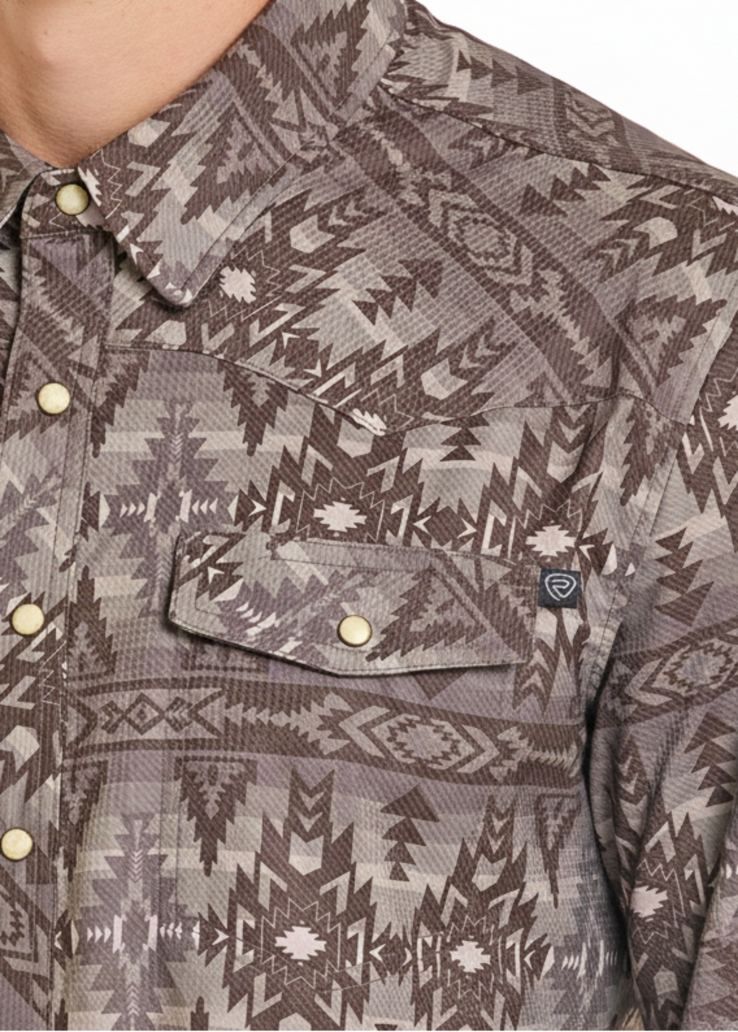 Close-up of a patterned shirt with a visible brand logo.