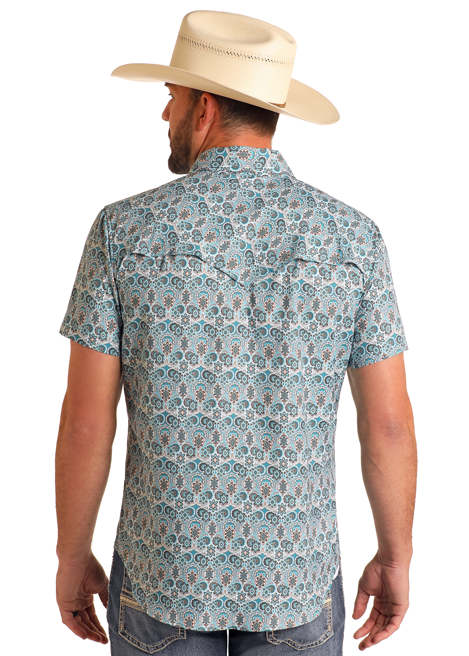 A man wearing a cream cowboy hat, blue jeans, and a Rock & Roll Denim TEK Western Geo Floral Print Short Sleeve Shirt stands with his back to the camera against a plain white background.