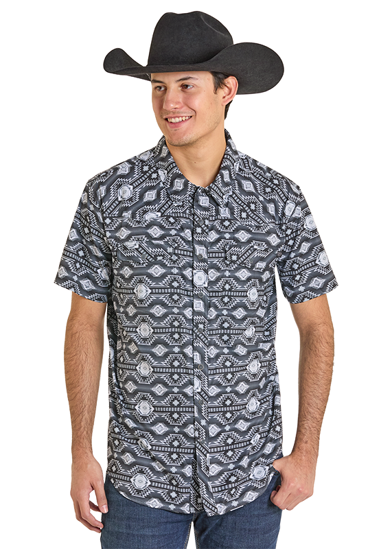 A young man smiles with his left hand in his pocket, wearing blue jeans and the Rock & Roll Denim TEK Western Black & Grey Aztec Short Sleeve Shirt, which offers moisture-wicking comfort against a plain white background.