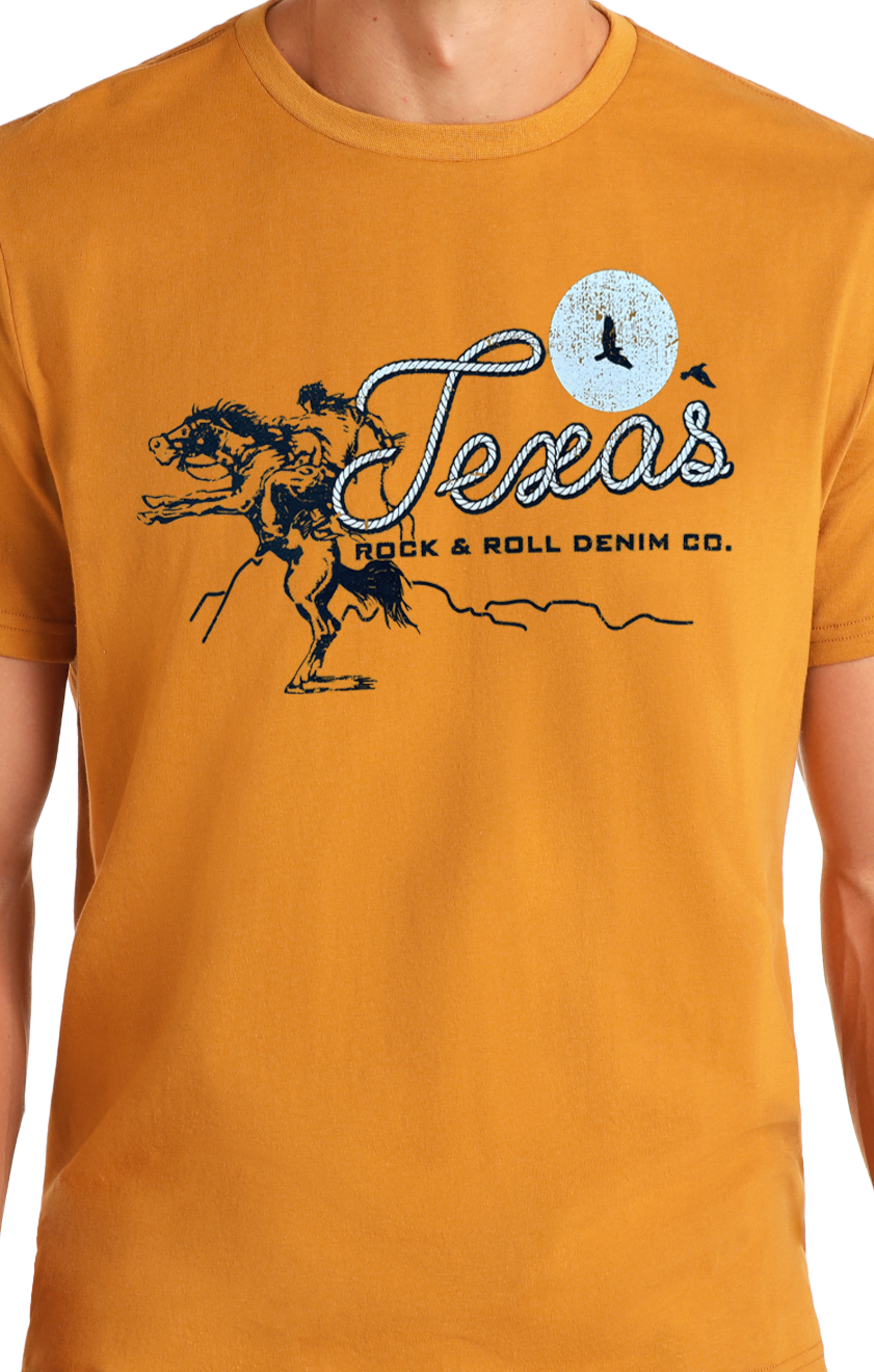A person wears the Texas Graphic Tee by Rock & Roll Denim, featuring a bucking horse, moon, and flying bird graphic with "Texas" and the brand name below. Designed for comfort, it's ideal for everyday wear.