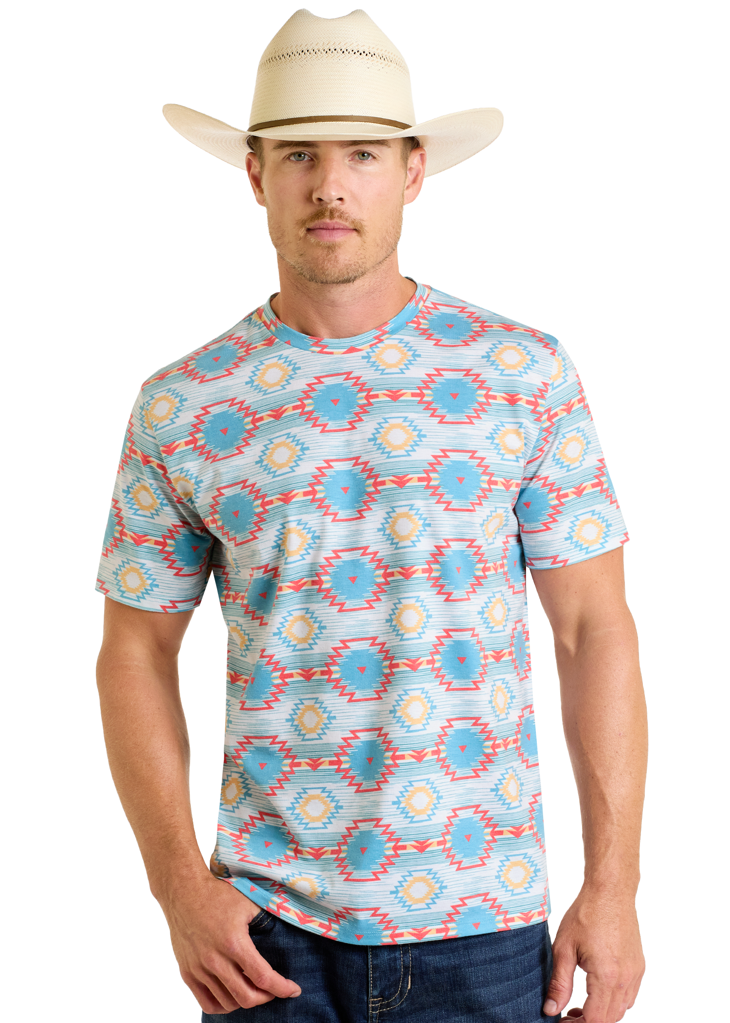 A man wearing a cream cowboy hat, blue jeans, and a Rock & Roll Denim Turquoise Aztec All Over Print Tee stands facing forward against a plain white background.