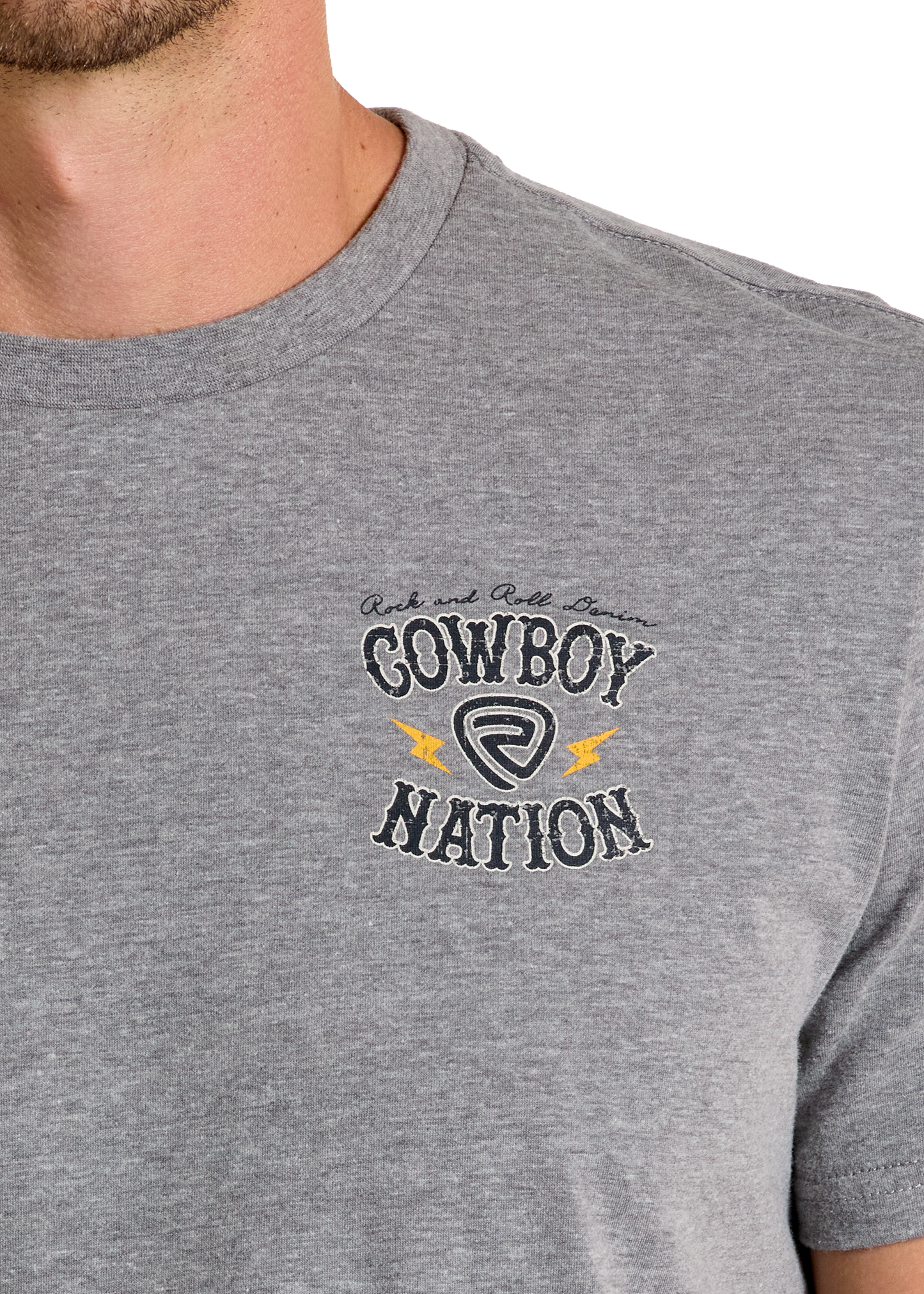 Close-up of a person wearing the Cowboy Nation Graphic Tee by Rock & Roll Denim, a comfy heather gray shirt featuring decorative script, yellow lightning bolts, and a circular emblem—ideal for everyday style.