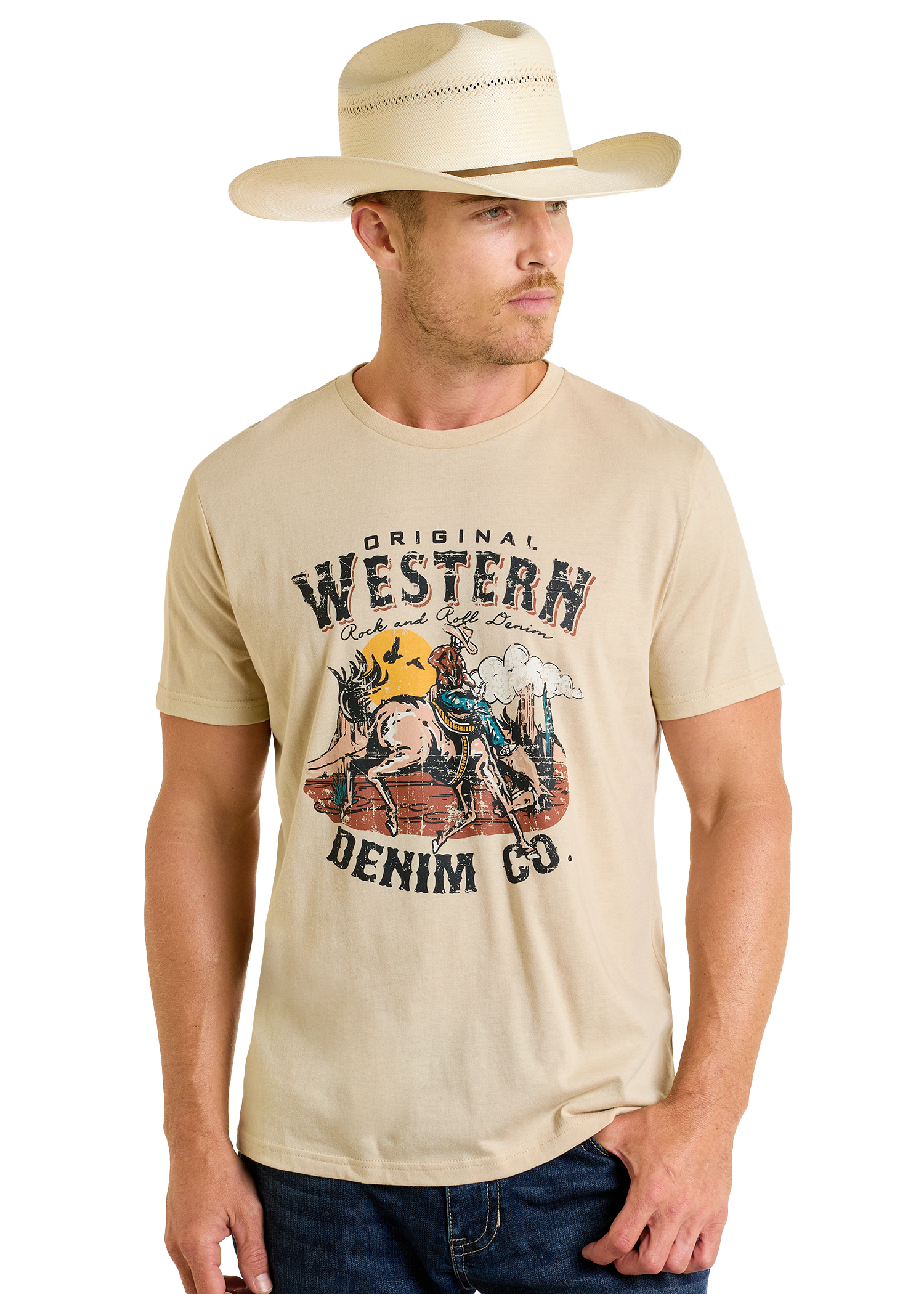 A man in a light cowboy hat and jeans wears the Rock & Roll Denim Original Western Denim Co. Graphic Tee, featuring a horse-and-desert design, while looking to the side.
