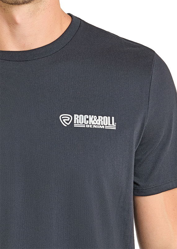 A person wears the Drinking Buddies Skull Graphic Tee by Rock & Roll Denim in dark gray, featuring a small white logo on the left chest. Only the upper torso, part of the left arm, and neck are visible.