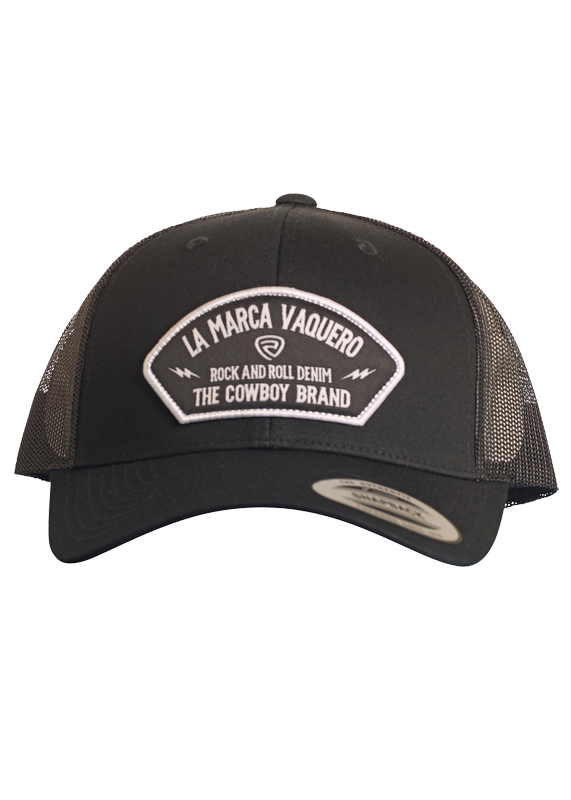 The La Marca Vaquero Cap by Rock & Roll Denim is a black trucker hat featuring a mesh back, adjustable snapback, and a front patch with "LA MARCA VAQUERO, ROCK AND ROLL DENIM, THE COWBOY BRAND" in white lettering.