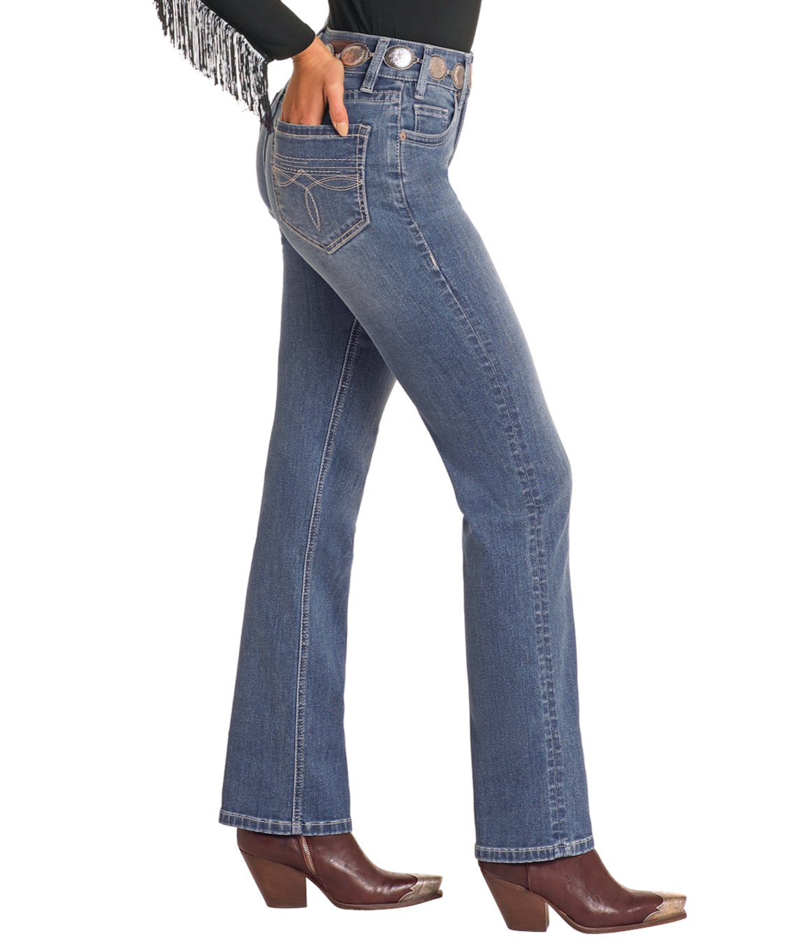 A person wears Rock & Roll Denim High Rise Bootstitch Modest Bootcut Jeans in Medium Wash (30x34), brown heeled boots, and a black fringed top, shown from the side against a white background.