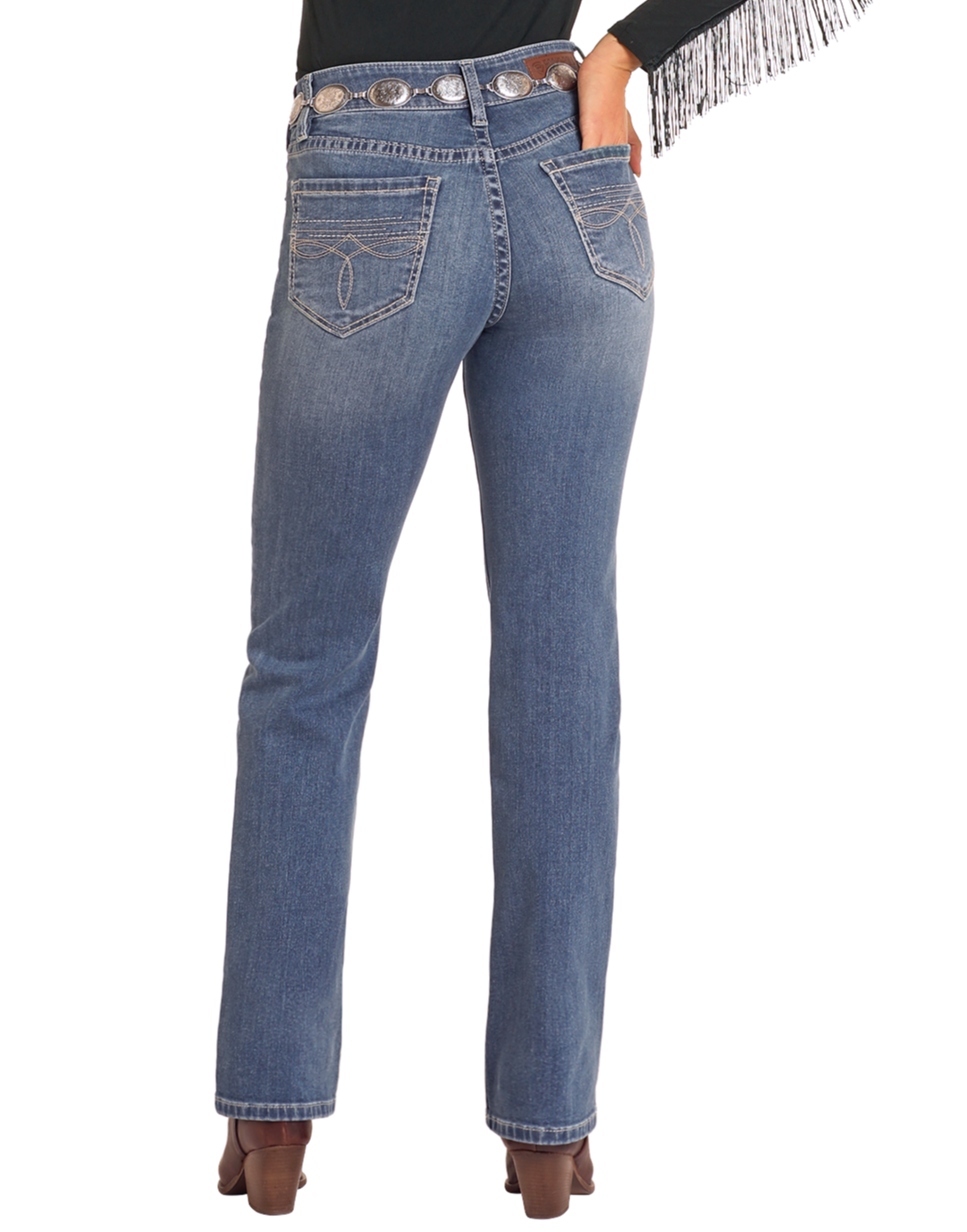 A person is seen from the back wearing Rock & Roll Denim High Rise Bootstitch Modest Bootcut Jeans in Medium Wash (30x34), a decorative belt, heeled brown boots, and a black top with fringed sleeves.