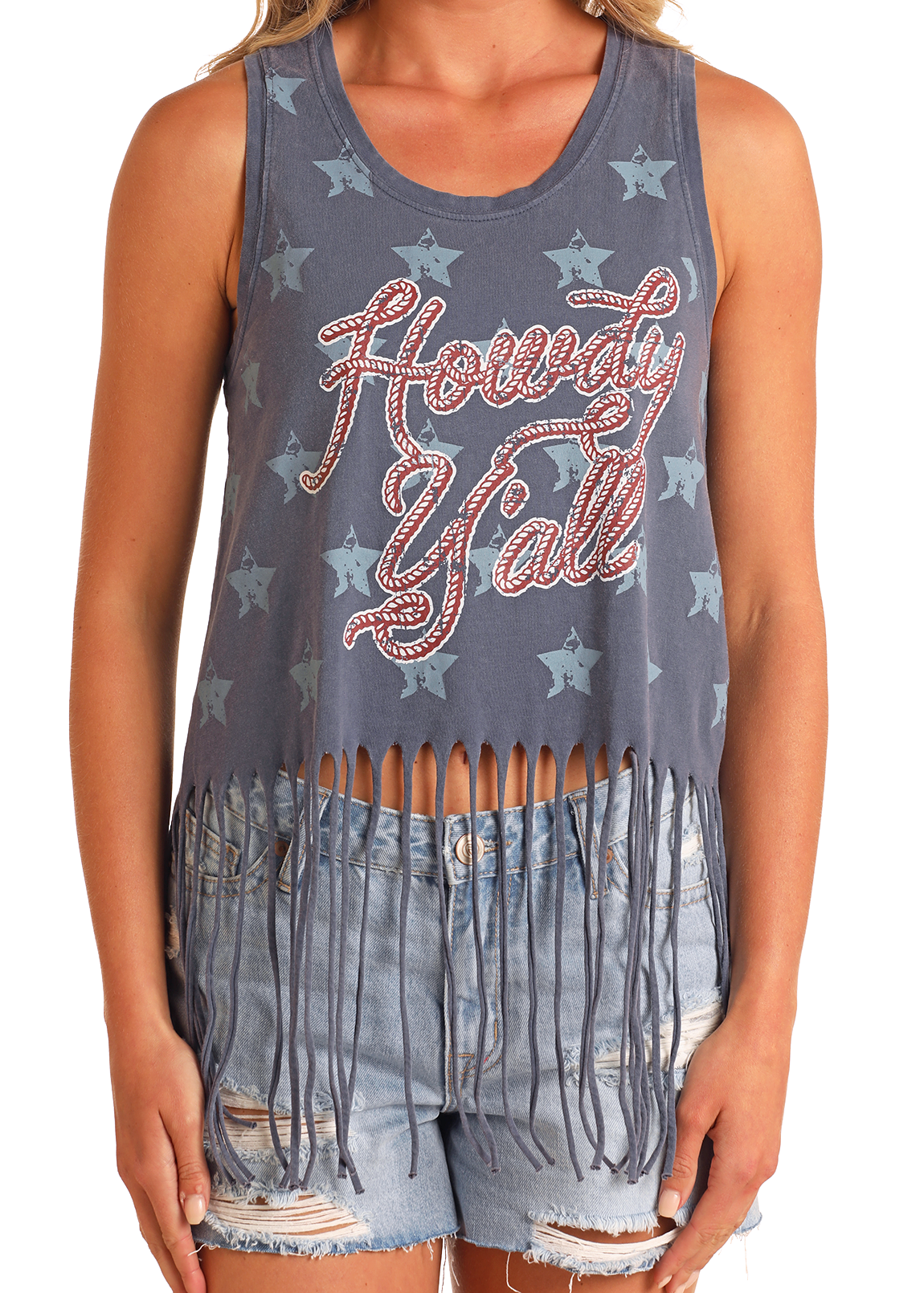 A person wears the Rock & Roll Denim Howdy Y'all Fringe Tank, featuring light blue stars and “Howdy Y’all” in red, paired with distressed denim shorts for an effortlessly cool, graphic look.