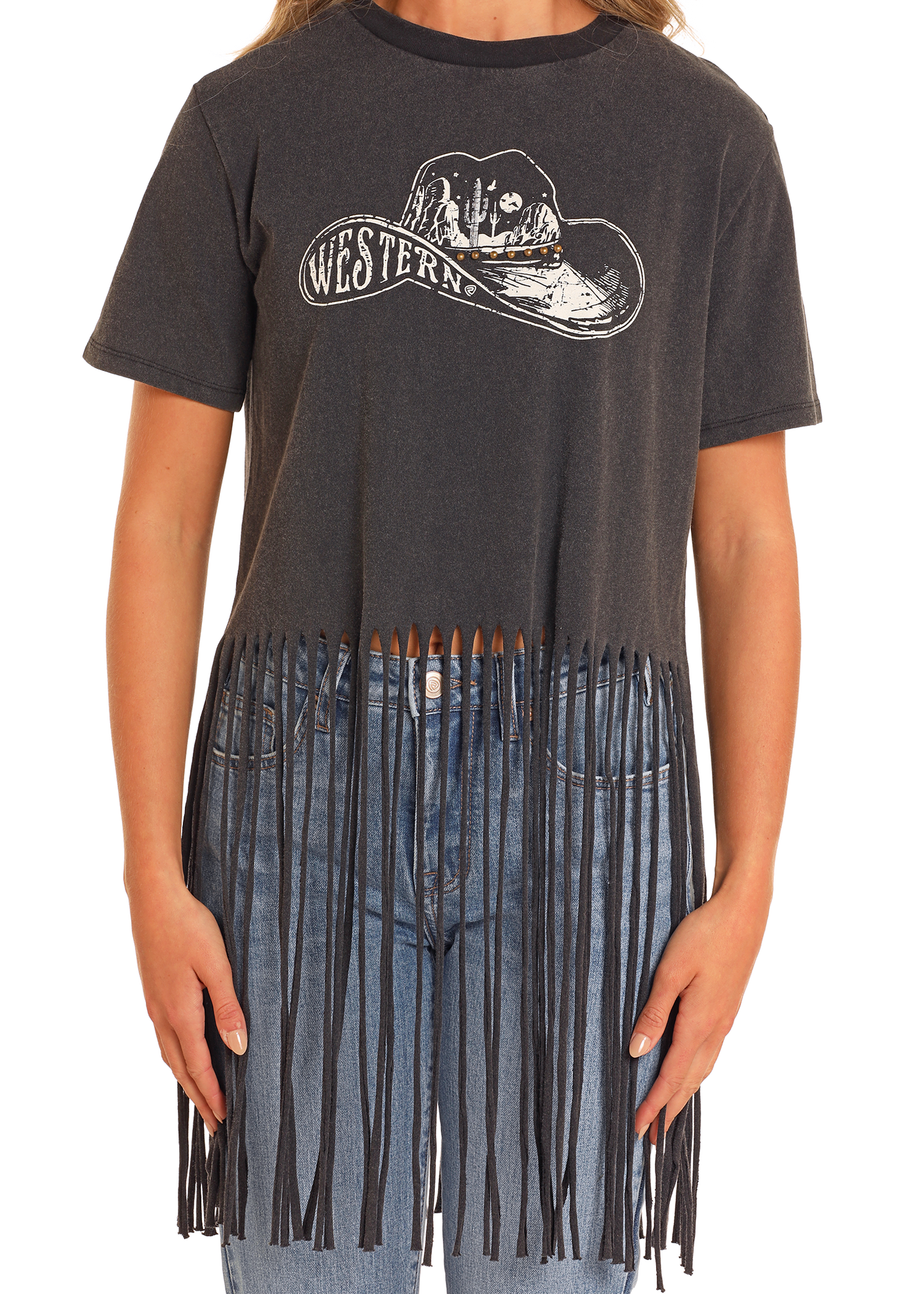 A person wears the Rock & Roll Denim West Desperado Studded Western Fringe Tee, featuring a cowboy hat graphic and "Western" text, with long fringe at the bottom, styled with blue jeans.