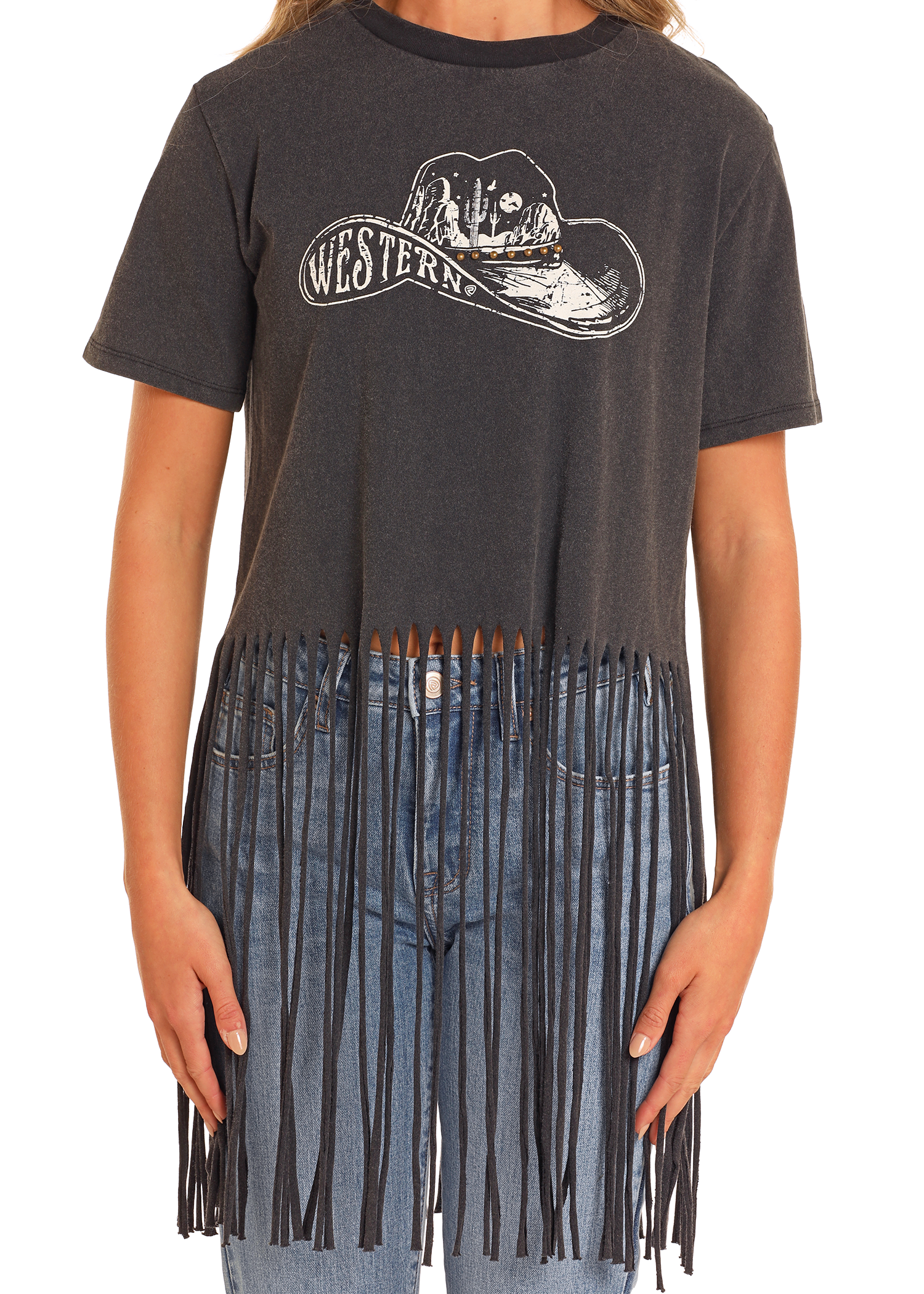 A person wears the Rock & Roll Denim West Desperado Studded Western Fringe Tee, featuring a cowboy hat graphic and "Western" text, with long fringe at the bottom, styled with blue jeans.