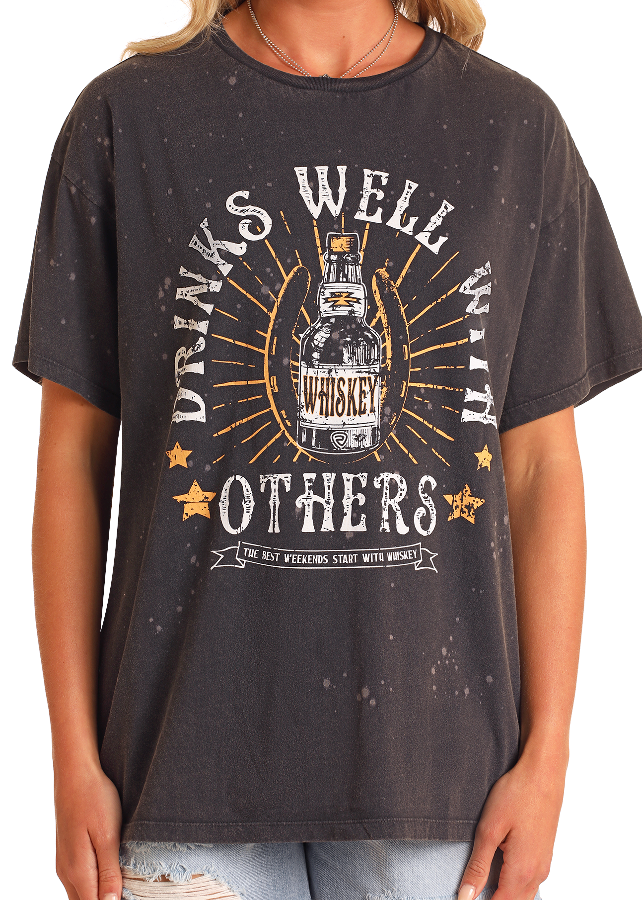 A person in the Rock & Roll Denim Drinks Well With Others Oversized Tee, featuring a distressed whiskey bottle graphic and playful text. This relaxed, slightly faded tee is ideal for laid-back weekends.