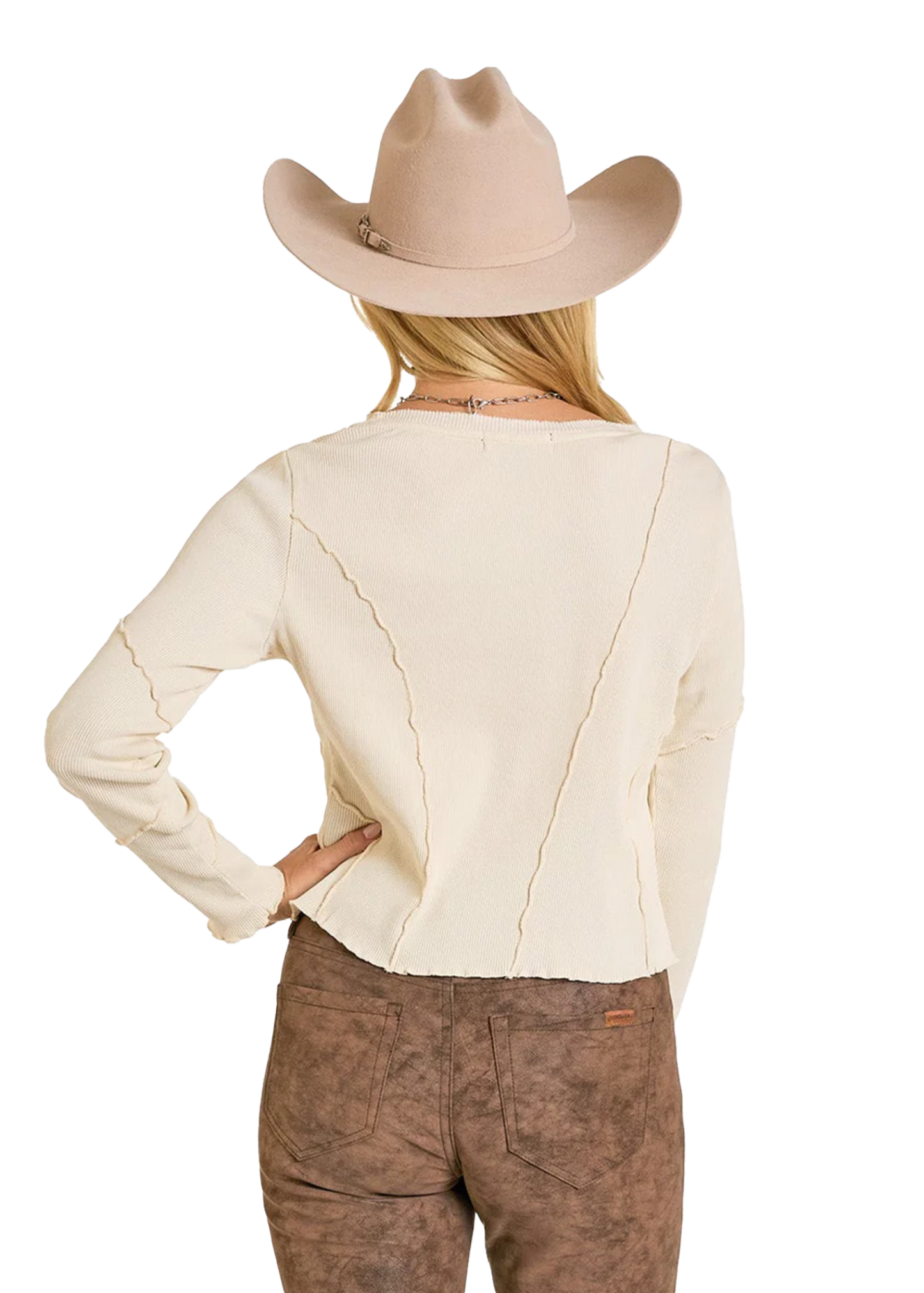 A woman is seen from the back with one hand on her hip, wearing a Rock & Roll Denim Exposed Seam Long Sleeve Shirt, a beige cowboy hat, and brown textured pants.