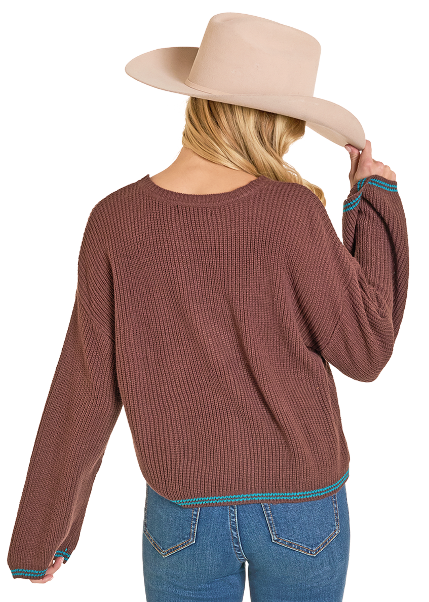 Person wearing a brown sweater and blue jeans with a beige hat on a white background