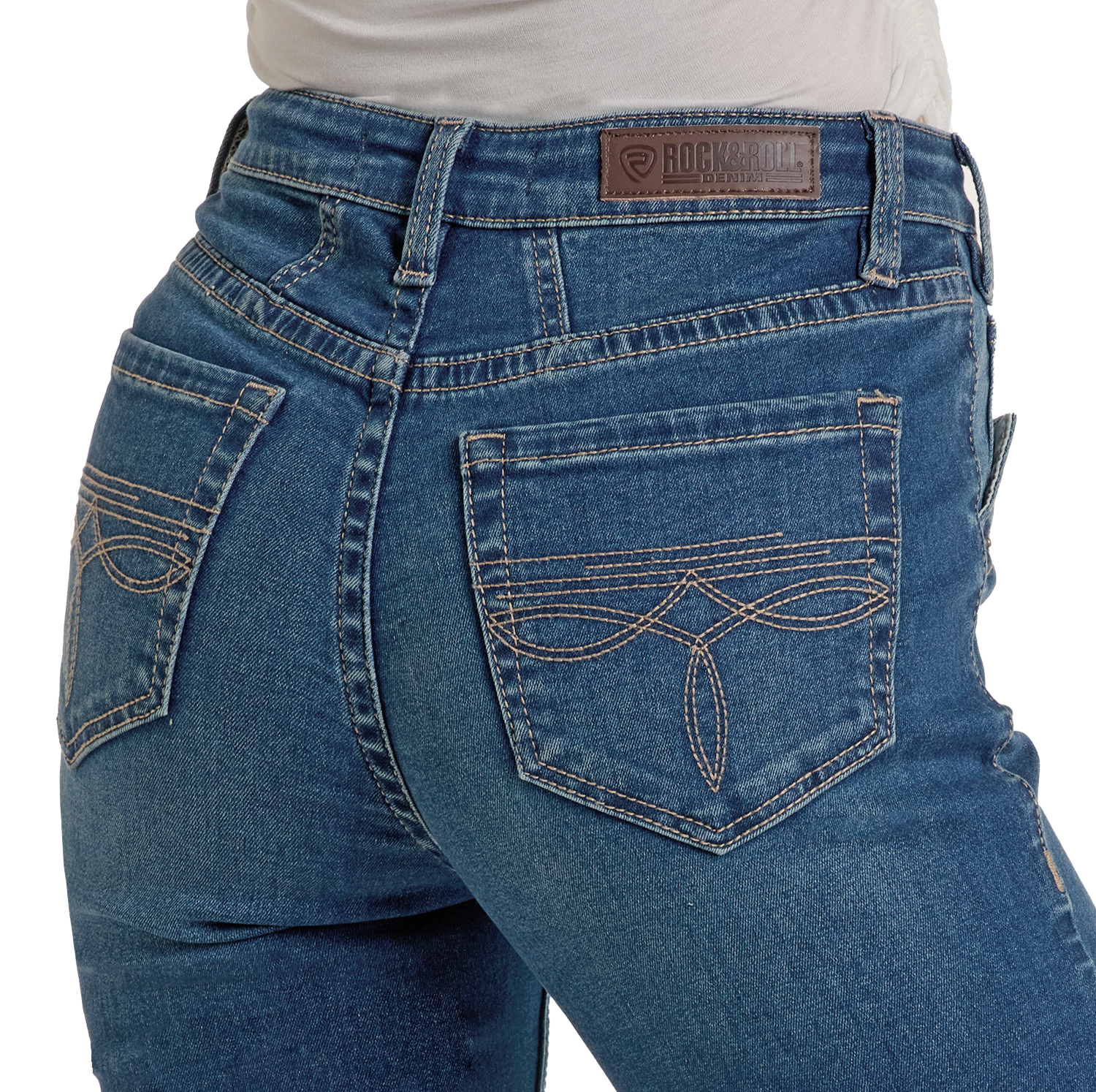 Close-up of a person wearing Rock & Roll Denim High Rise Two Tone Bootcut Jeans with decorative back pocket stitching, a brown leather brand patch on the waistband, and a tucked-in white shirt.