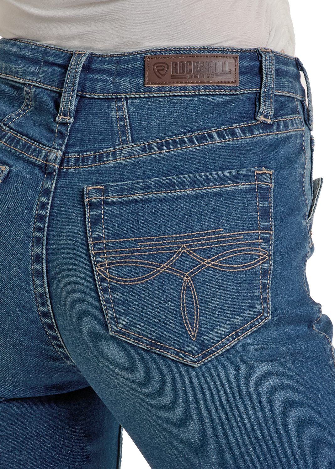 Close-up of a person wearing Rock & Roll Denim High Rise Two Tone Bootcut Jeans with decorative back pocket stitching, a brown leather brand patch on the waistband, and a tucked-in white shirt.