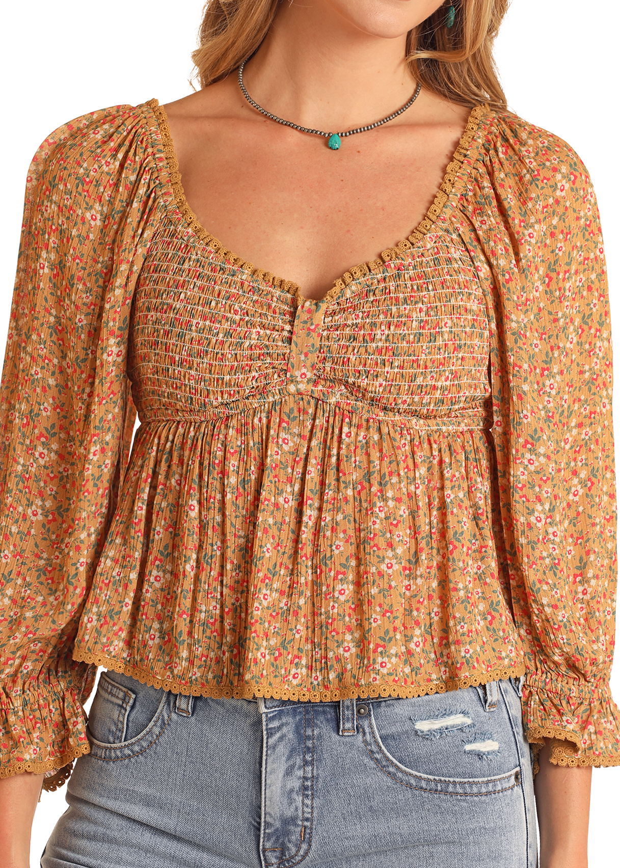 A woman wears the Rock & Roll Denim Ditsy Floral Blouse with elastic lantern sleeves, a flowy bodice, and a deep neckline, paired with light blue high-waisted ripped jeans. Her face is partially out of frame.