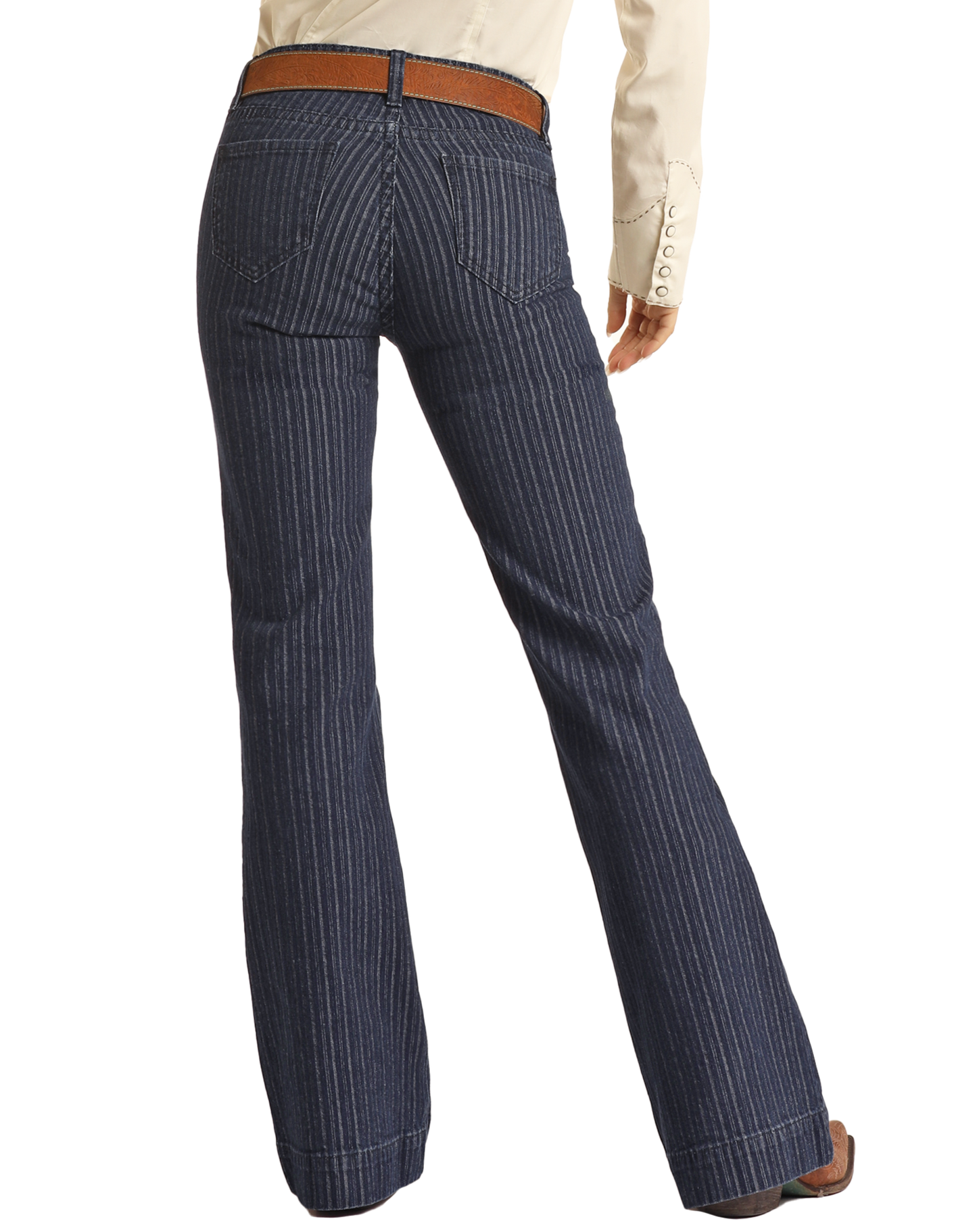 A person wearing Rock & Roll Denim Jacquard Mid Rise Trouser Jeans with pinstripes, rear pockets, and a flared bottom stands with their back to the camera, paired with a brown belt and cream shirt for western sophistication.