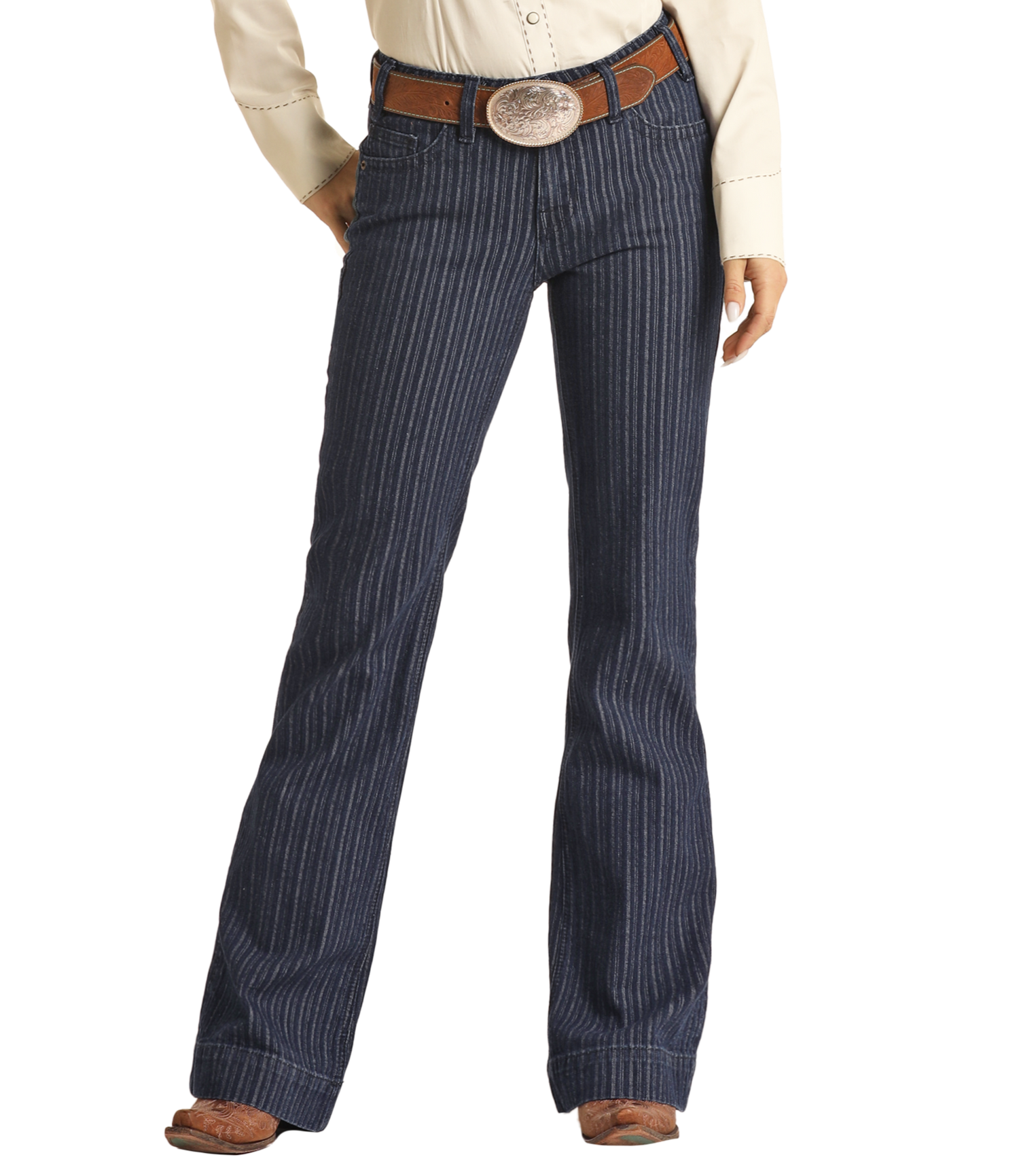 A person stands against a white background wearing Rock & Roll Denim’s Jacquard Mid Rise Trouser Jeans, styled with a brown leather belt, cream Western-style shirt, and brown cowboy boots for a look of western sophistication.
