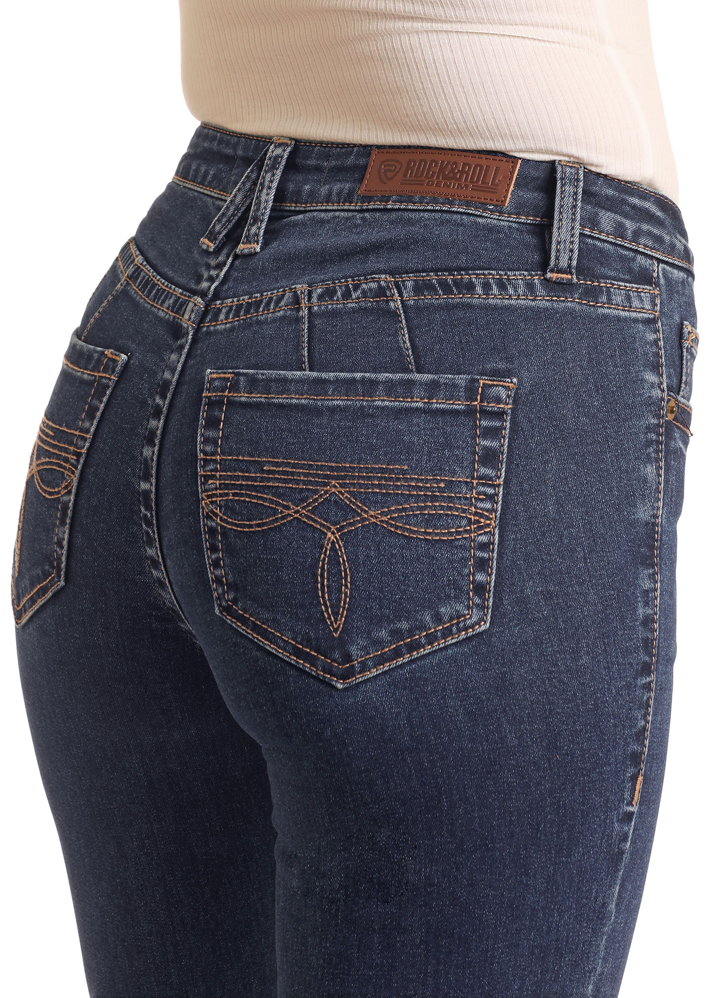 Close-up of a person wearing Rock & Roll Denim’s Mid Rise Boot Stitch Trousers with embroidered pockets and a brown leather brand patch, paired with a light ribbed shirt.