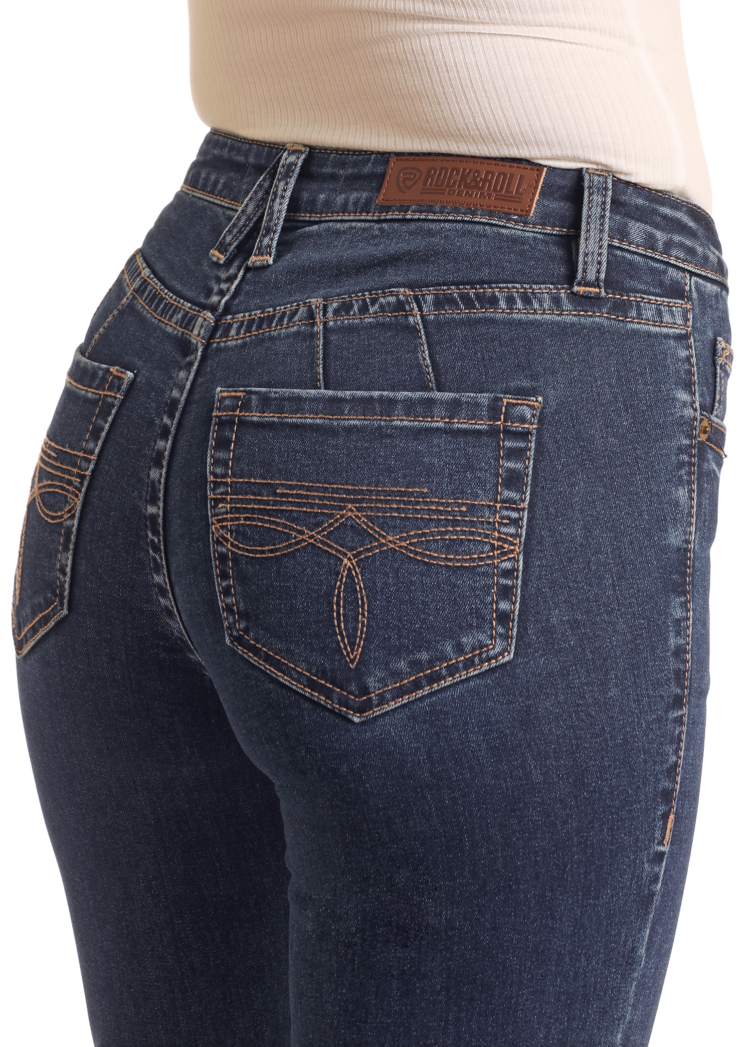 Close-up of a person wearing Rock & Roll Denim’s Mid Rise Boot Stitch Trousers with embroidered pockets and a brown leather brand patch, paired with a light ribbed shirt.