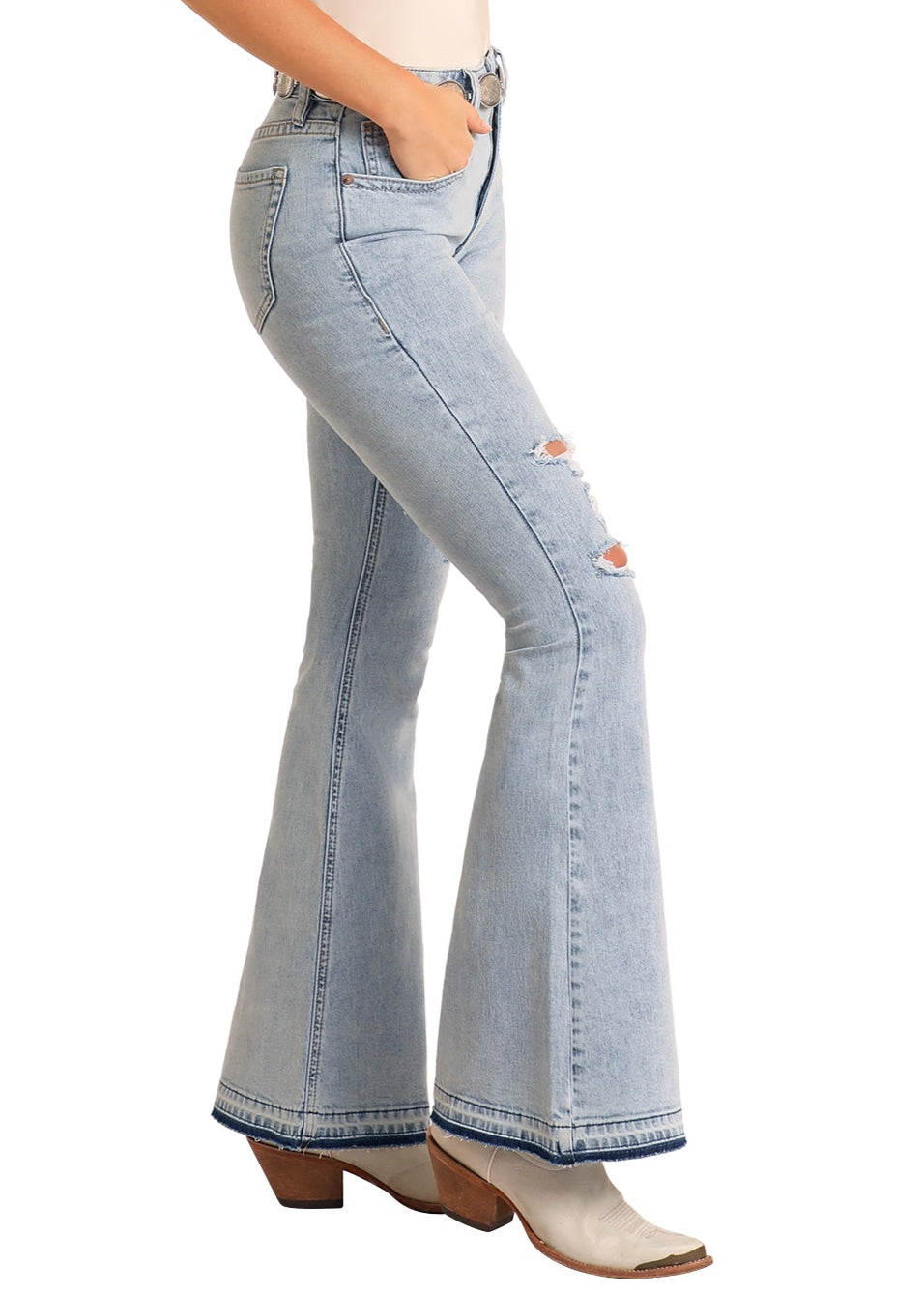 Woman wearing light blue flared jeans and a beige hat on a white background