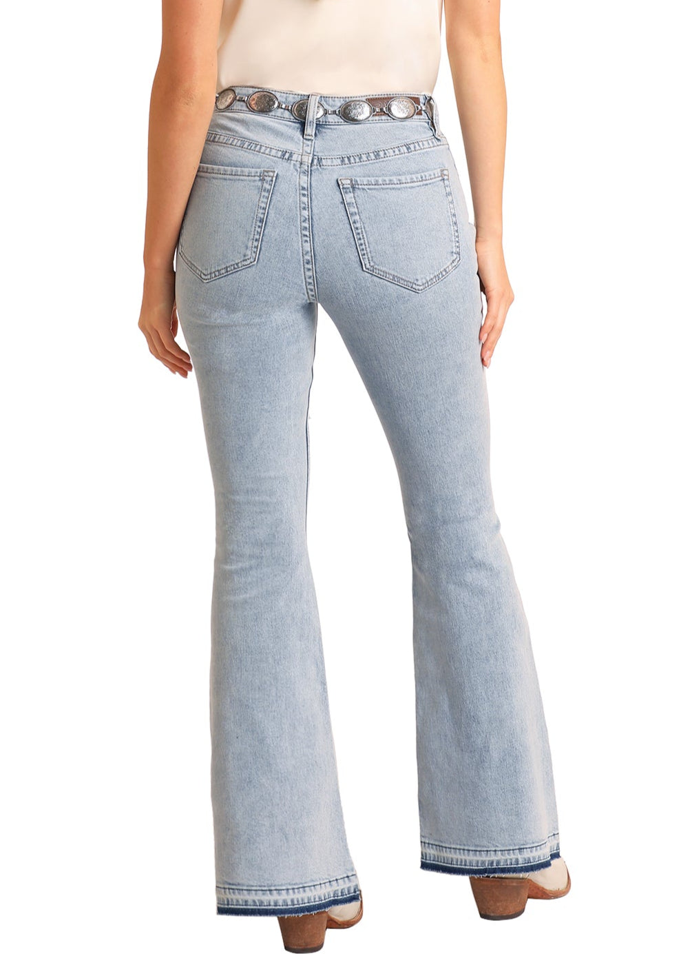 Woman wearing light blue jeans and a beige cowboy hat on a white background