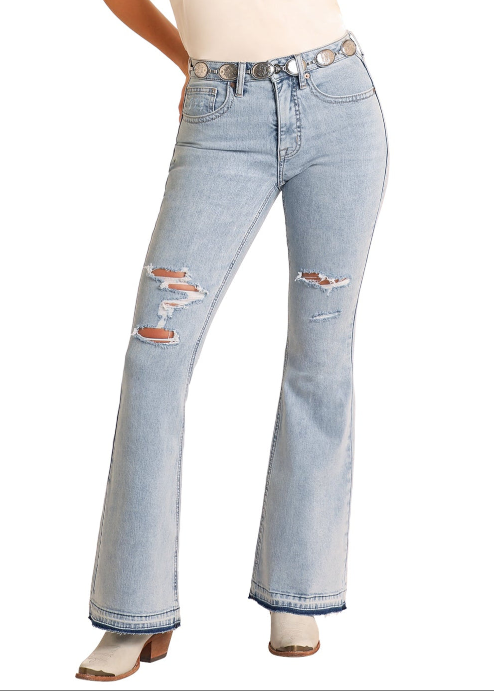 Woman wearing light blue distressed jeans and a beige tank top on a white background