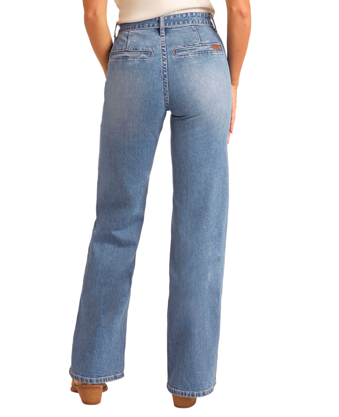 A person faces away, showcasing the back of Rock & Roll Denim High Rise Belted Relaxed Flare Jeans in light blue with faux back pockets and straight legs, paired with brown platform shoes against a white background.