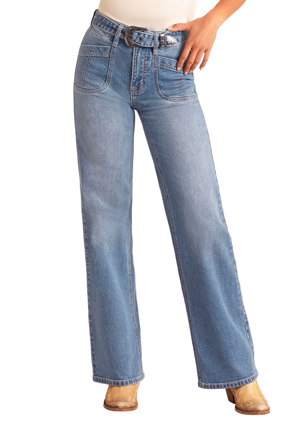 A person wears Rock & Roll Denim High Rise Belted Relaxed Flare Jeans in light blue with front pockets and a denim Western belt, styled with tan shoes and a tucked-in white top. The person's face is not shown.