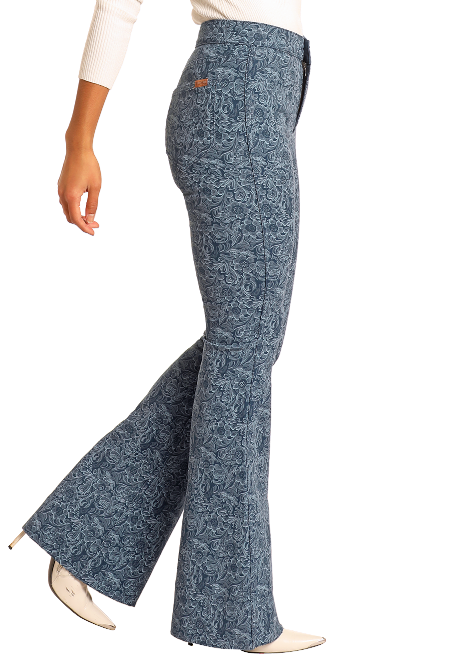 A person wearing Rock & Roll Denim Reversible Floral Button Flare Jeans, a white long-sleeve top, and white pointed-toe heeled shoes, shown from the side against a plain background.