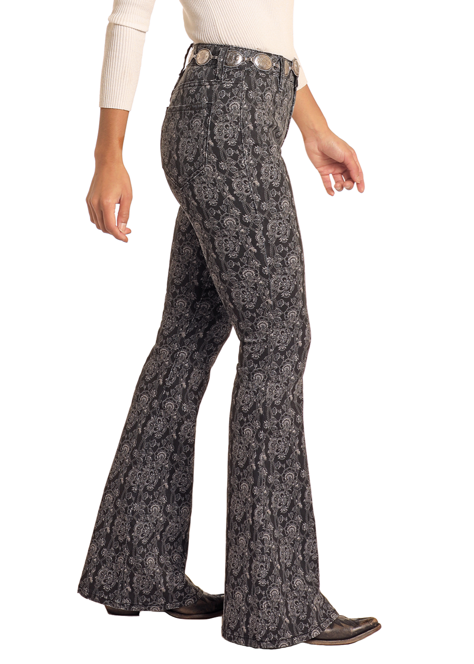 Woman wearing a white top and patterned bell-bottom pants with a brown hat on a white background