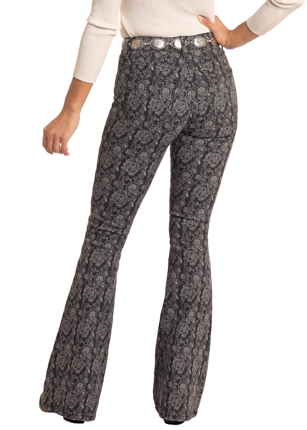 Woman wearing a white long-sleeve top and patterned flared pants with a brown hat on a white background