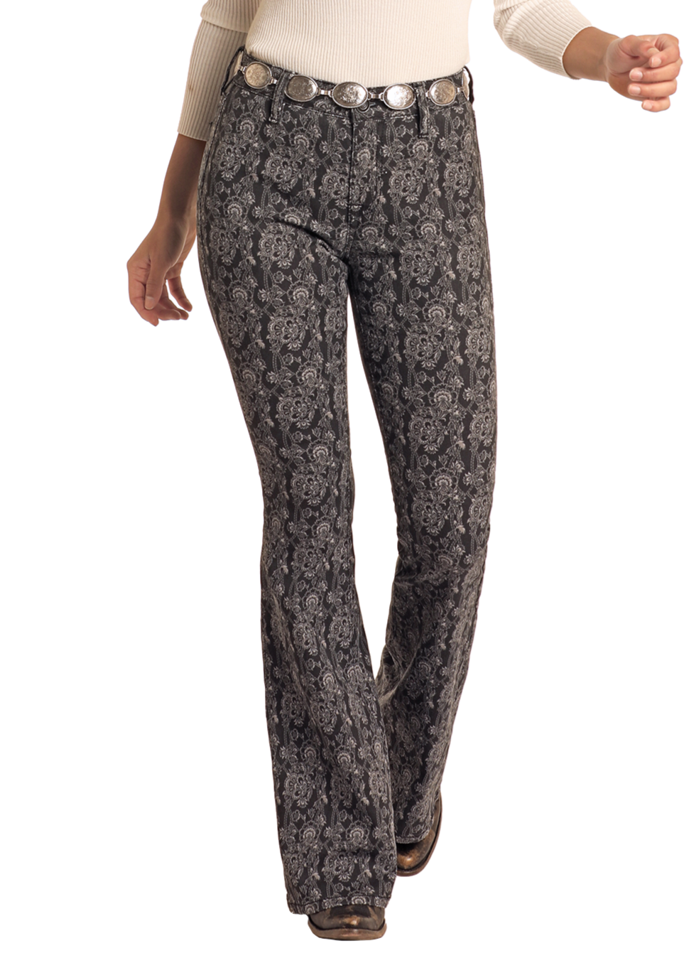 Woman wearing a cowboy hat, cream top, and patterned pants on a white background