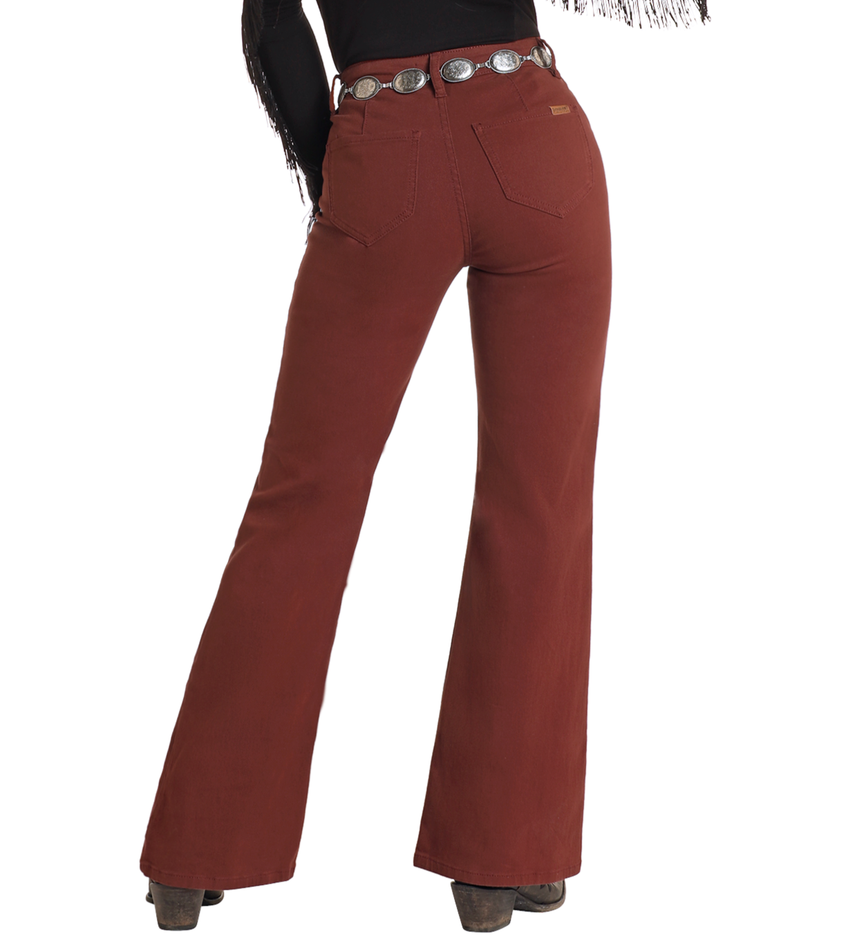 A person wearing Rock & Roll Denim High Rise Wide Leg Flare Jeans, a black fringe top, silver concho belt, and heeled boots is shown from the back against a white background.