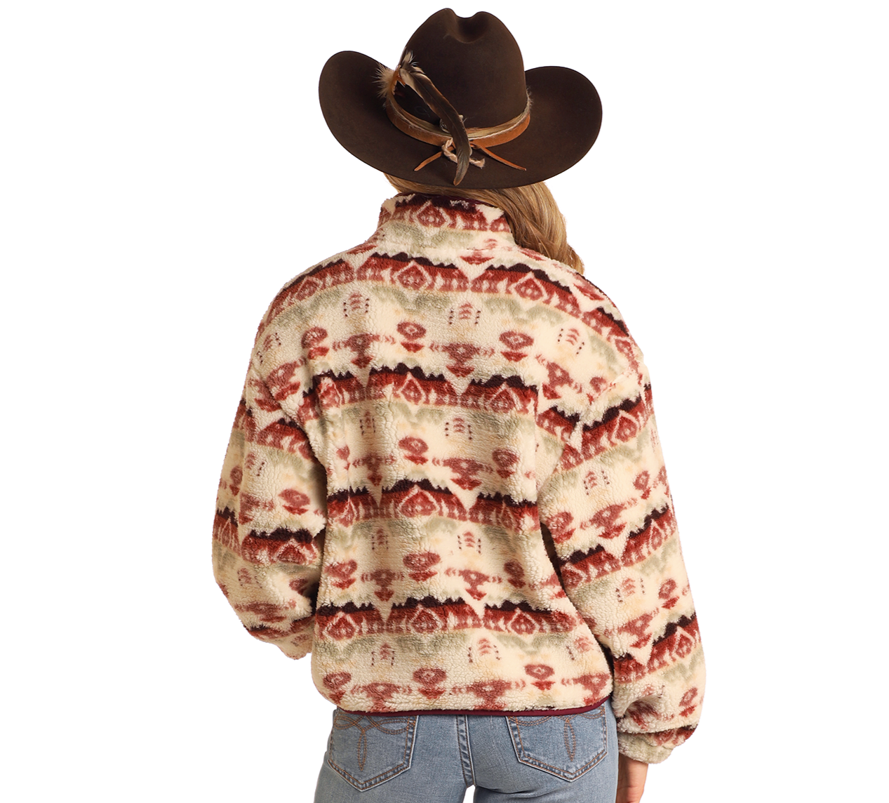 A person stands facing away against a white background, wearing light blue jeans and the Rock & Roll Denim Aztec Print Sherpa Pullover with red and beige tones, paired with a wide-brimmed brown cowboy hat.