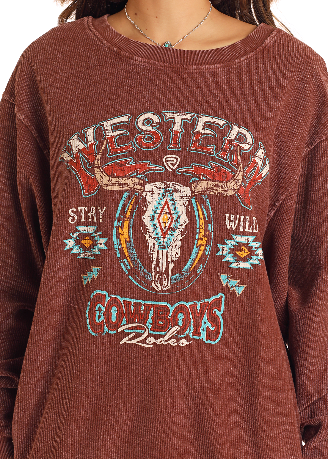 Someone wearing the Rock & Roll Denim Western Cowboys Ribbed Pullover featuring a brown corduroy design, steer skull graphic with turquoise and red patterns, and "Western," "Stay Wild," and "Cowboys Rodeo" text.