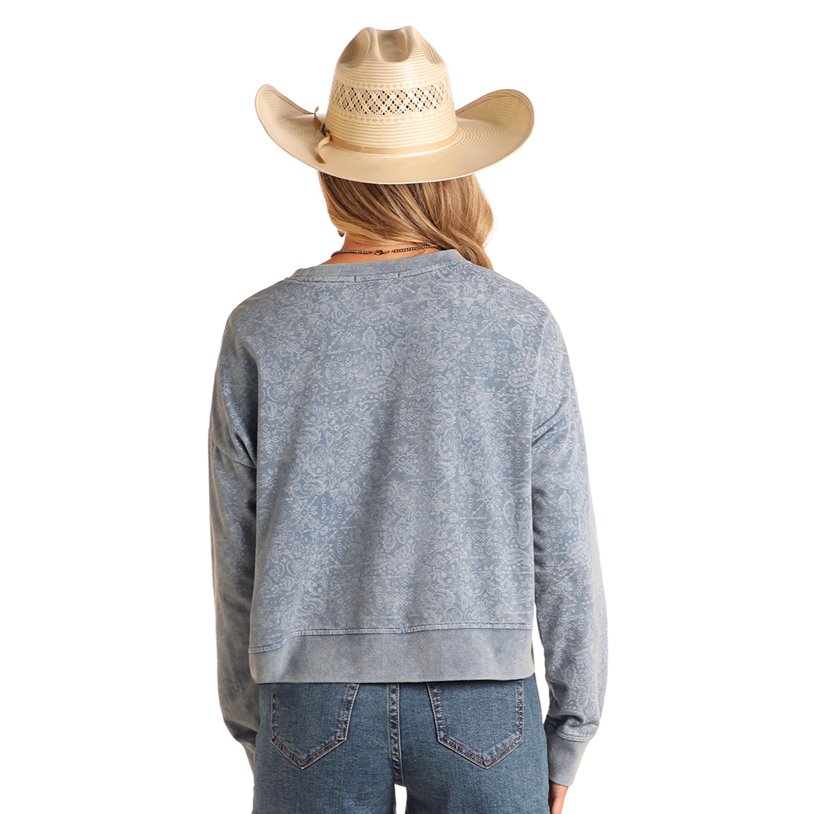 A person wearing Rock & Roll Denim's Bandana Print Pullover in light blue, a tan cowboy hat, and blue jeans faces away from the camera against a plain white background.