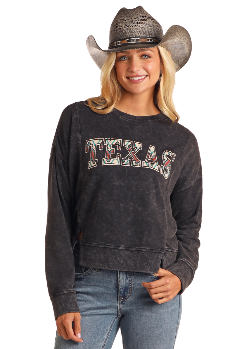 A smiling woman wears a Rock & Roll Denim Texas Graphic Pullover, gray cowboy hat, and blue jeans, standing against a white background.