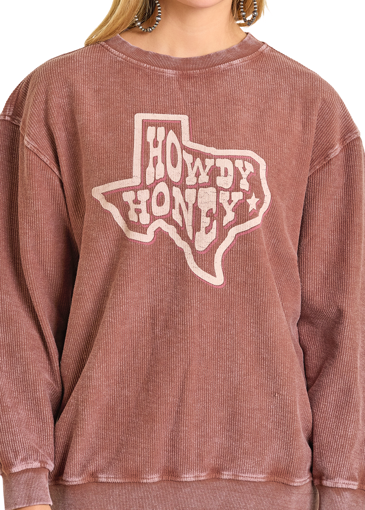 A person wears the mauve corduroy Howdy Graphic Pullover by Rock & Roll Denim, featuring a bold Texas state outline with "Howdy Honey" printed inside.