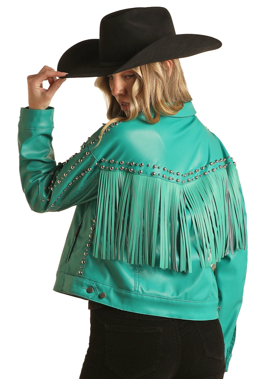Person wearing a turquoise leather jacket with fringe and studs, holding a black cowboy hat.