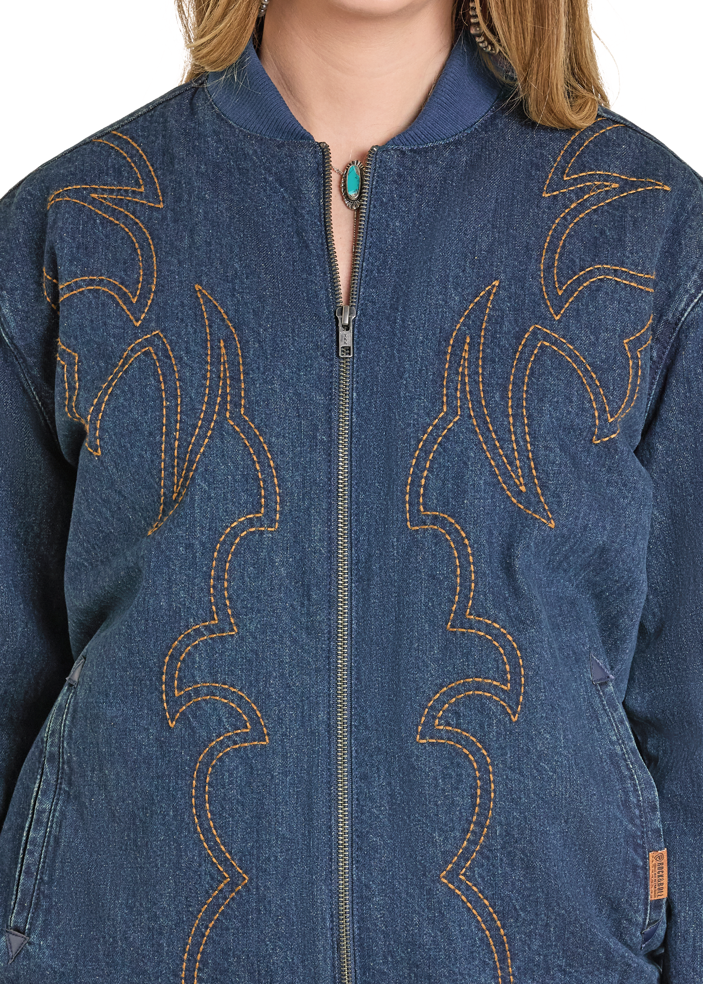 Close-up of a blue denim jacket with intricate stitching details.