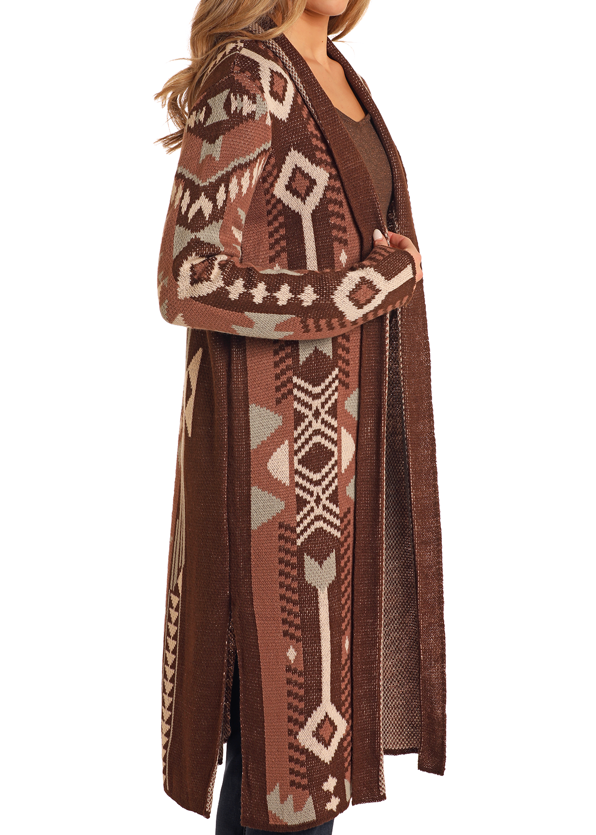 A woman models the Rock & Roll Denim Brown Aztec Duster, an open-front cardigan with a tribal-inspired beige and gray pattern, worn over a brown top and dark pants. Only her upper body and part of her face are visible.