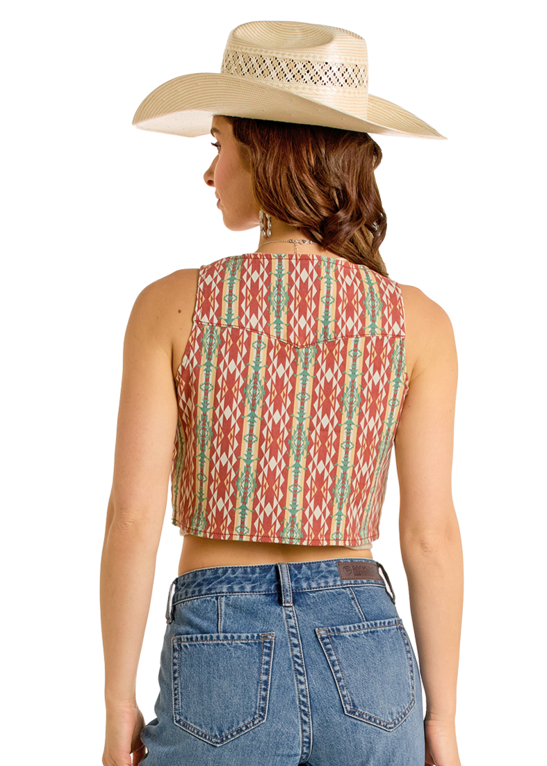 Woman wearing a patterned sleeveless top and blue jeans with a cowboy hat on a white background
