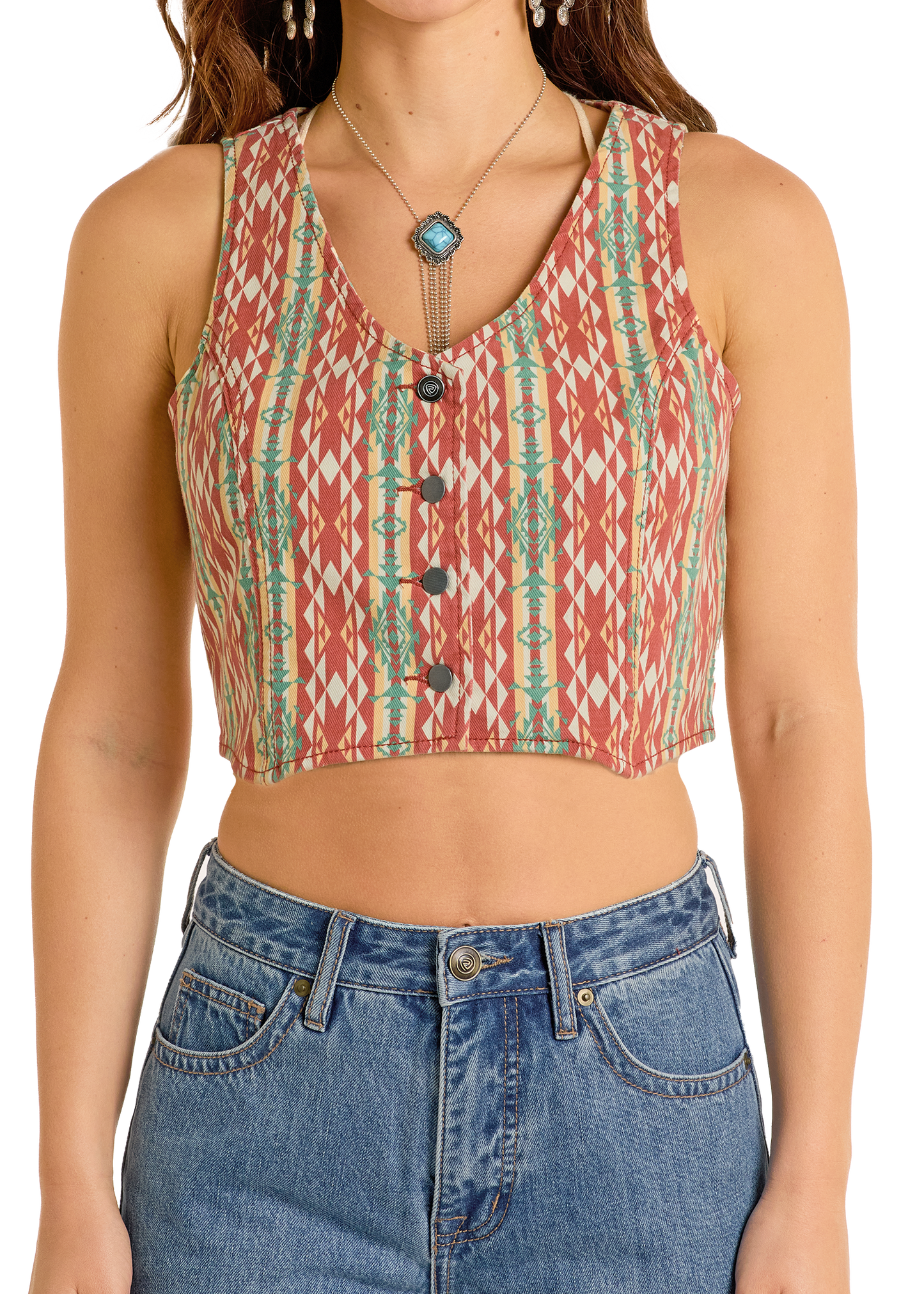 Person wearing a patterned sleeveless top and blue jeans on a white background