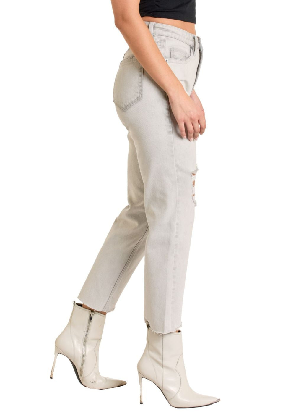 Woman wearing a black top and light gray pants on a white background