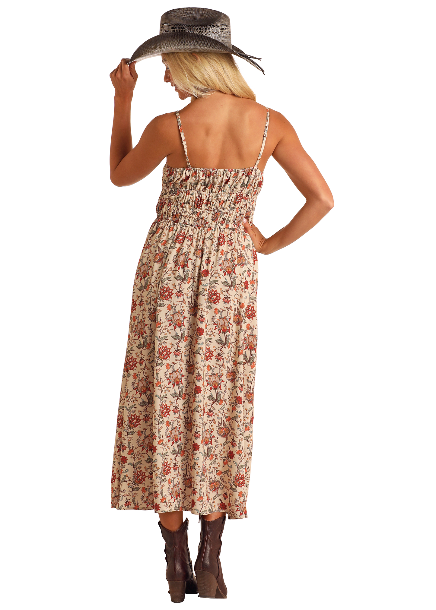 A woman with long blonde hair, wearing the Rock & Roll Denim Cream Floral Print Midi Dress, brown ankle boots, and a wide-brimmed hat, stands facing away and gently holds the brim of her hat.