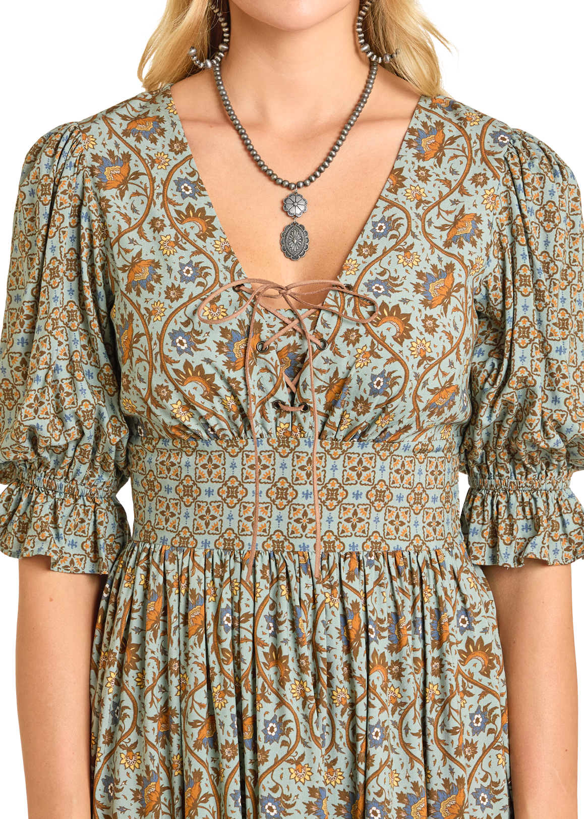 A woman wears the Rock & Roll Denim Mixed Print Mini Dress, featuring light blue and brown prints, puffed sleeves, lace-up V-neckline, high waist, paired with a silver pendant necklace.