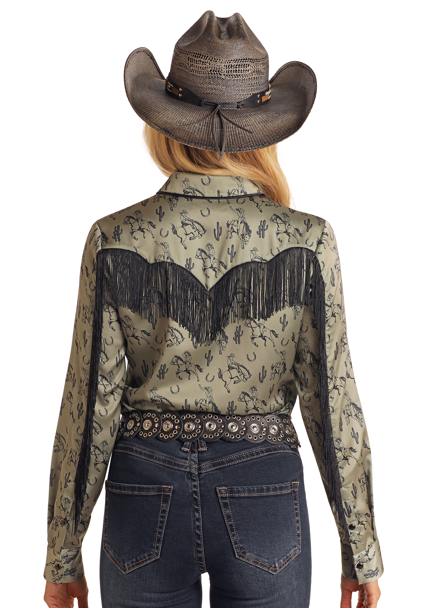 A woman seen from behind wears a grey cowboy hat, dark blue jeans, a decorative black belt, and a green Rock & Roll Denim Western Print Long Sleeve Satin Shirt with black fringe and desert pattern.