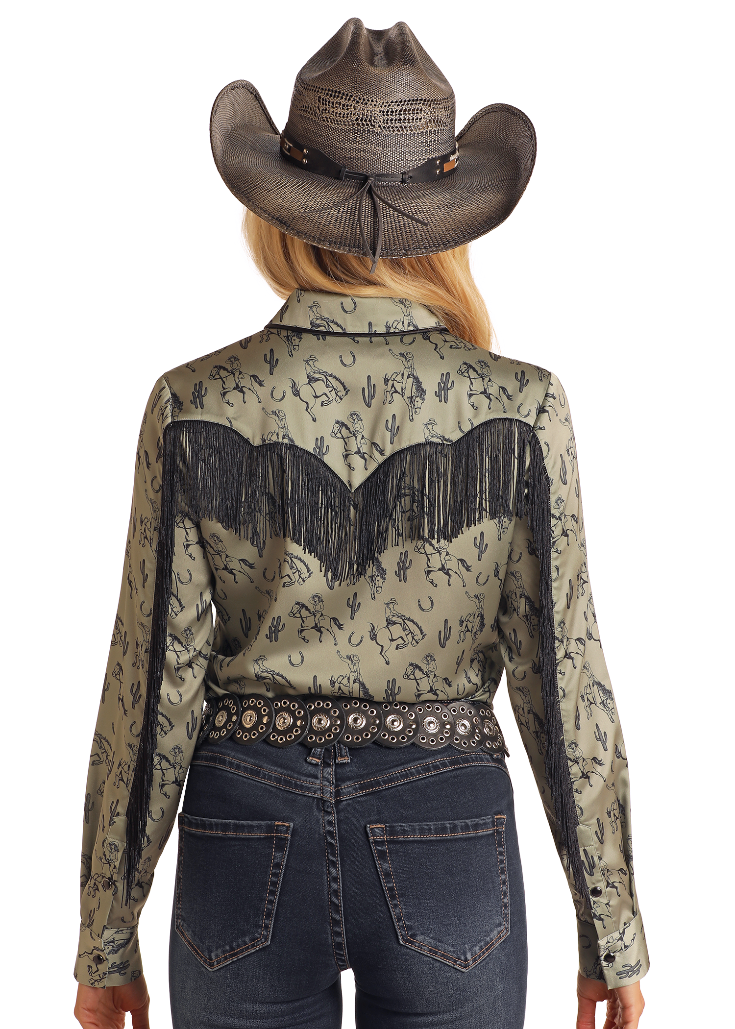 A woman seen from behind wears a grey cowboy hat, dark blue jeans, a decorative black belt, and a green Rock & Roll Denim Western Print Long Sleeve Satin Shirt with black fringe and desert pattern.